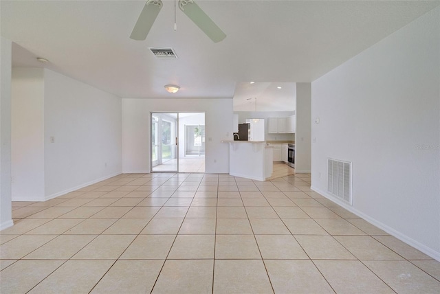 tiled empty room featuring ceiling fan and vaulted ceiling