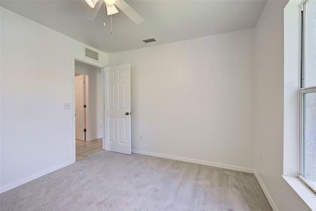 carpeted spare room with ceiling fan