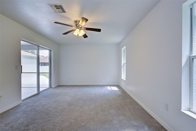 carpeted spare room featuring ceiling fan