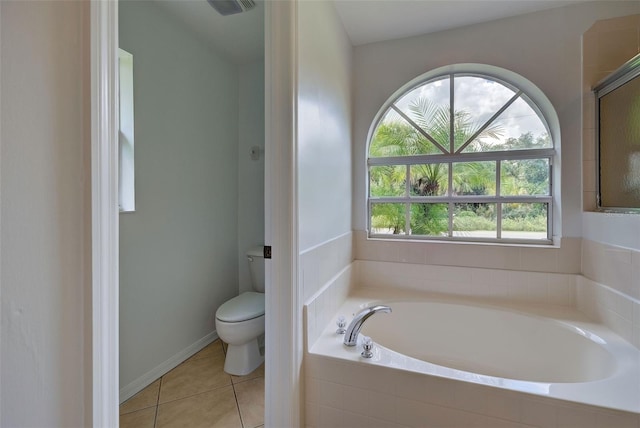 bathroom featuring tiled bath, plenty of natural light, toilet, and tile patterned flooring