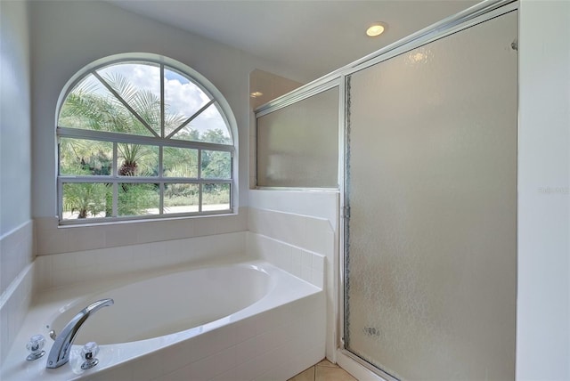 bathroom featuring plus walk in shower, plenty of natural light, and tile patterned flooring