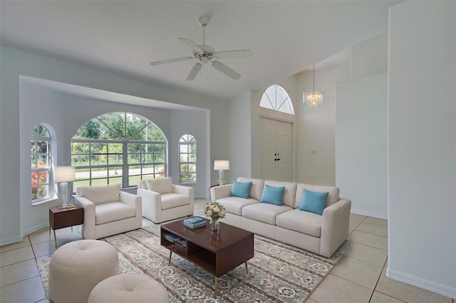 tiled living room with ceiling fan with notable chandelier