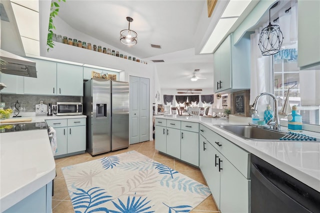 kitchen with pendant lighting, range hood, appliances with stainless steel finishes, sink, and ceiling fan