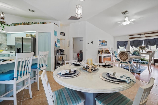 tiled dining room with vaulted ceiling and ceiling fan