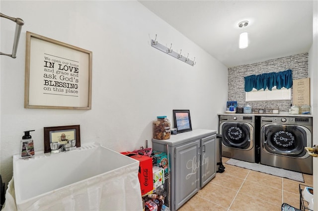 clothes washing area featuring washing machine and dryer, cabinets, sink, and light tile patterned floors