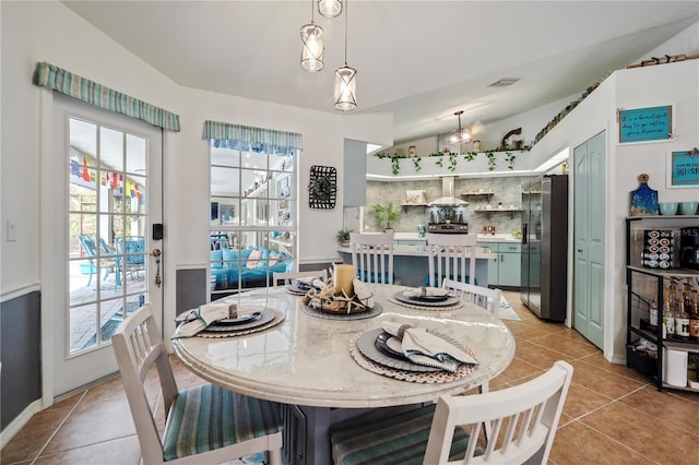 dining room with vaulted ceiling and light tile patterned flooring