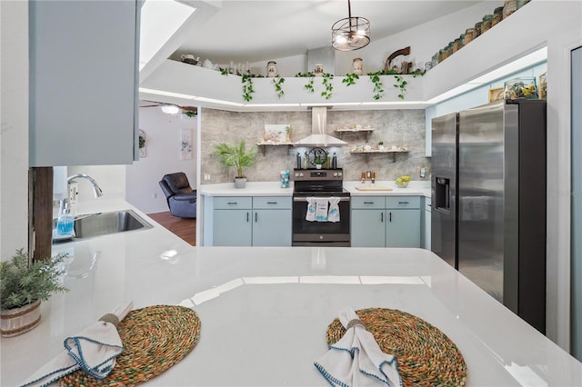 kitchen featuring decorative light fixtures, appliances with stainless steel finishes, sink, wall chimney exhaust hood, and decorative backsplash