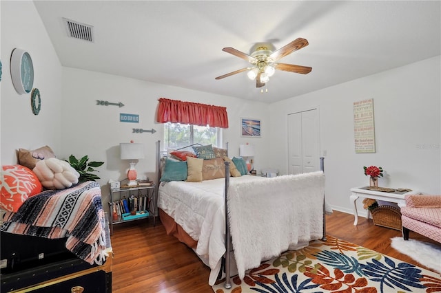 bedroom with dark hardwood / wood-style flooring, ceiling fan, and a closet