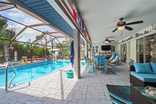 view of swimming pool with glass enclosure, a patio area, and ceiling fan