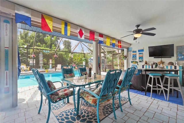 sunroom featuring ceiling fan and a healthy amount of sunlight