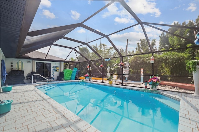 view of swimming pool with glass enclosure and a patio