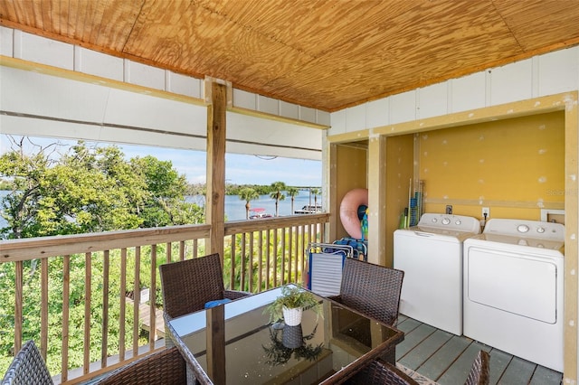 laundry room featuring washer and clothes dryer, a water view, and wooden ceiling