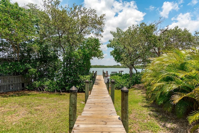 dock area with a lawn and a water view