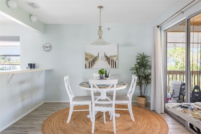 dining space with a wealth of natural light and wood-type flooring