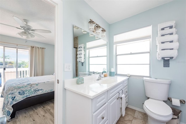 bathroom with wood-type flooring, ceiling fan, vanity, and toilet