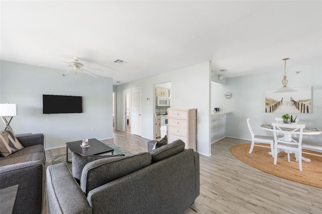 living room featuring light hardwood / wood-style floors and ceiling fan