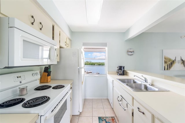 kitchen with white appliances, sink, light tile patterned floors, and white cabinets