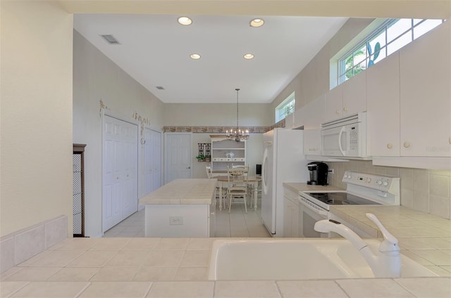 kitchen featuring pendant lighting, a notable chandelier, white appliances, sink, and white cabinets