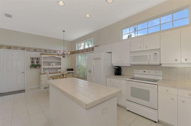 kitchen with a center island, decorative light fixtures, white appliances, a chandelier, and white cabinetry