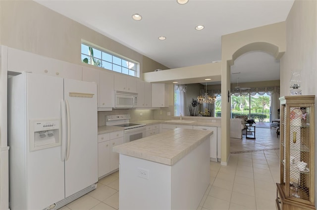 kitchen with white cabinetry, white appliances, a kitchen island, and sink