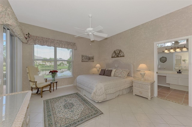 bedroom with ceiling fan, sink, light tile patterned floors, and ensuite bathroom