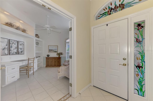 entrance foyer with built in desk, ceiling fan, and light tile patterned floors