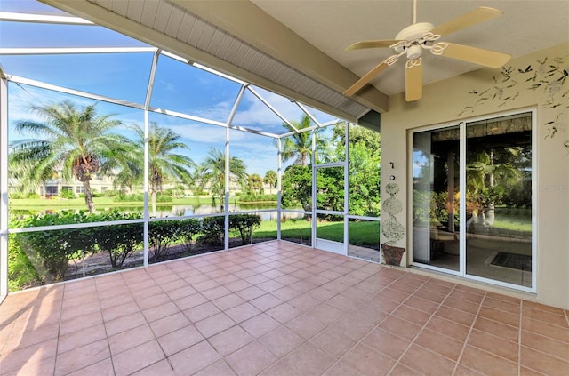 unfurnished sunroom featuring ceiling fan and a water view