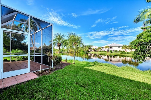 view of yard featuring a deck with water view and a lanai