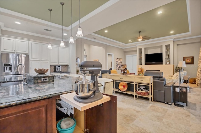 kitchen with white cabinets, a tray ceiling, ceiling fan, sink, and stainless steel fridge with ice dispenser