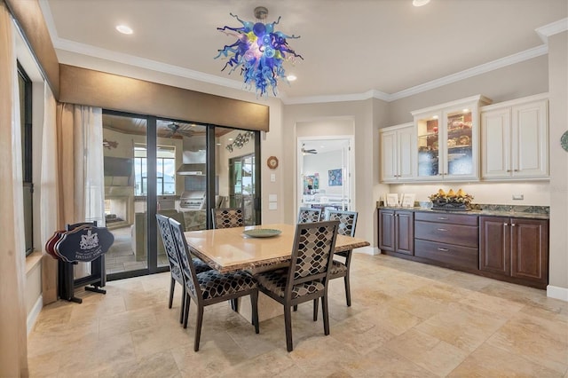 dining space with ceiling fan, a fireplace, and crown molding