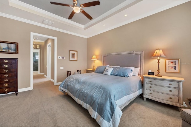 bedroom with ceiling fan, light colored carpet, a tray ceiling, and crown molding