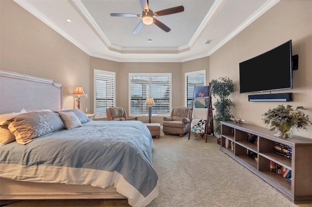 carpeted bedroom featuring a tray ceiling, ornamental molding, and ceiling fan