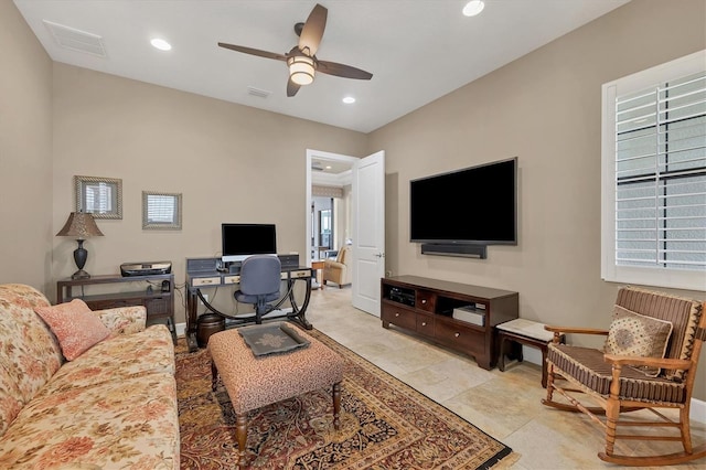 tiled living room with a wealth of natural light and ceiling fan