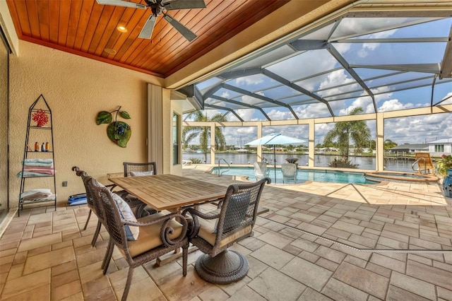 view of patio / terrace with a water view, a lanai, and ceiling fan