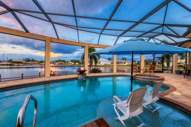 pool at dusk with a water view, an in ground hot tub, a patio area, and glass enclosure