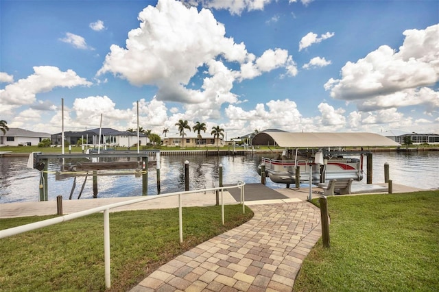 dock area with a lawn and a water view