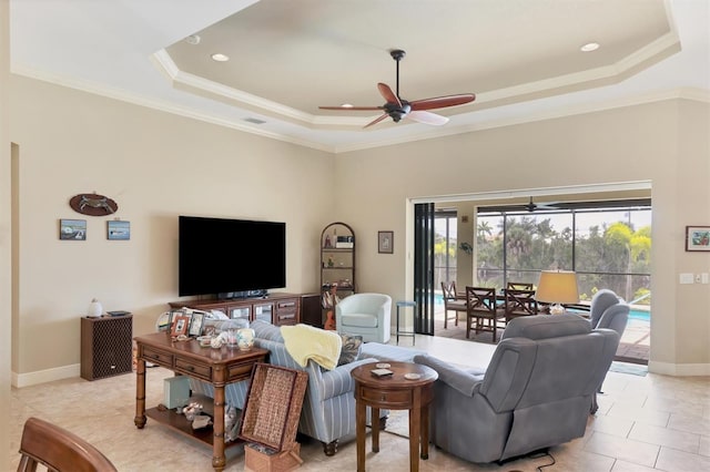 living room with a tray ceiling, plenty of natural light, light tile patterned floors, and ceiling fan