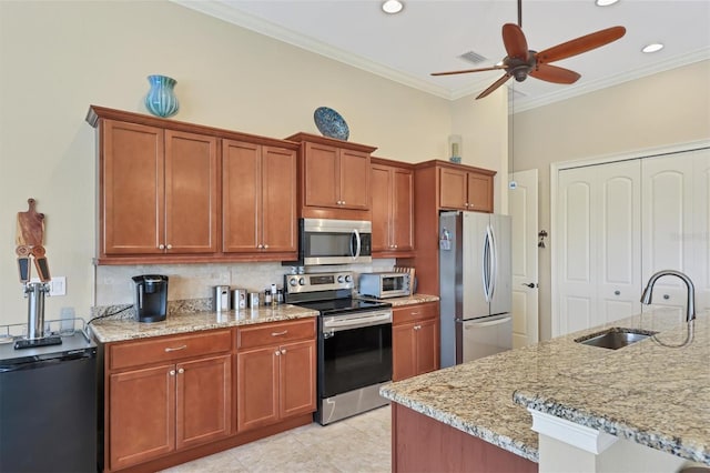 kitchen featuring light tile patterned floors, appliances with stainless steel finishes, light stone counters, sink, and ceiling fan