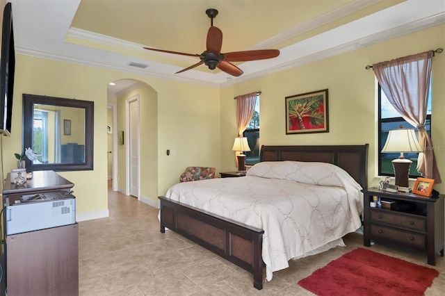 bedroom with ornamental molding, multiple windows, a raised ceiling, and ceiling fan