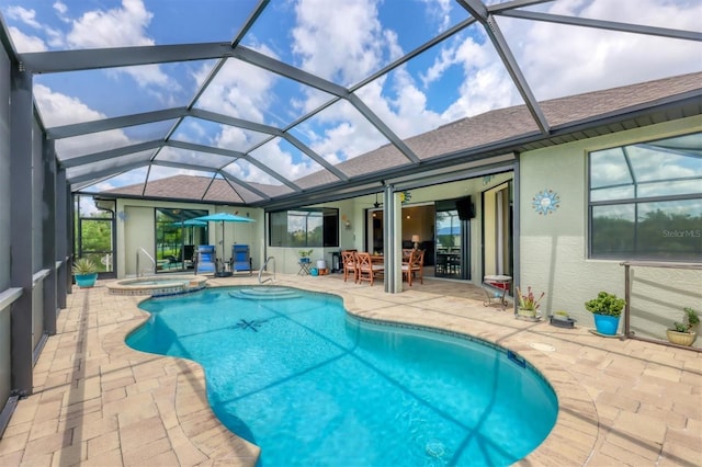 view of swimming pool featuring a lanai, a patio area, and an in ground hot tub