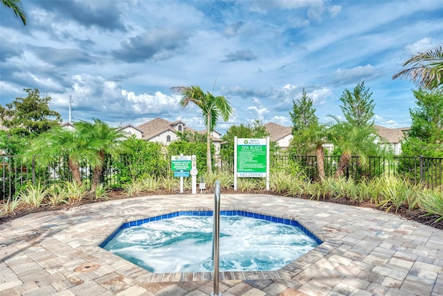 view of swimming pool with a hot tub