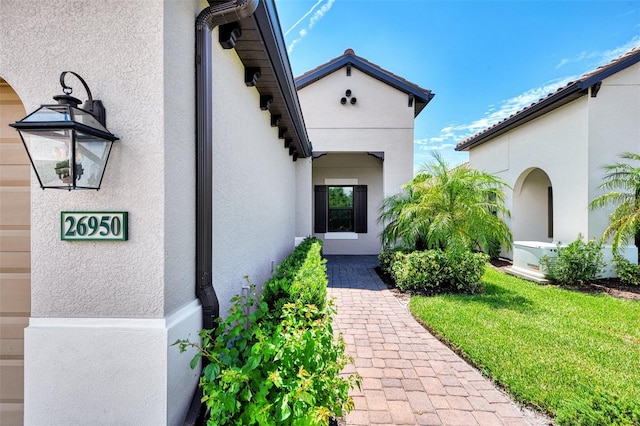 property entrance with a lawn