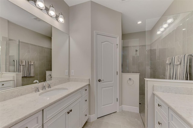 bathroom featuring vanity, tile patterned floors, and a tile shower