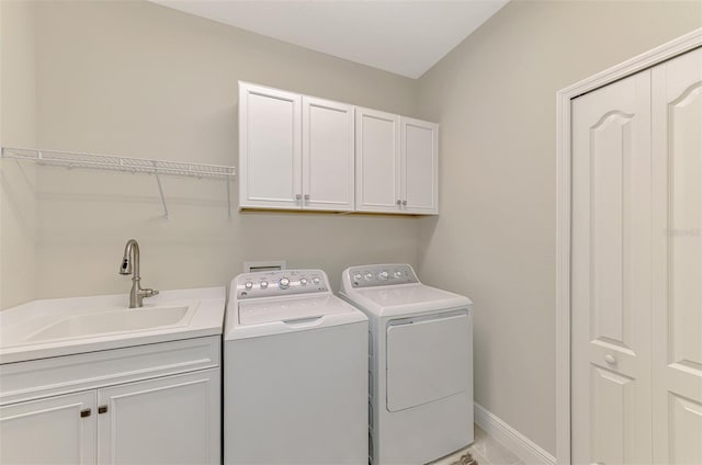 laundry room with independent washer and dryer, cabinets, and sink