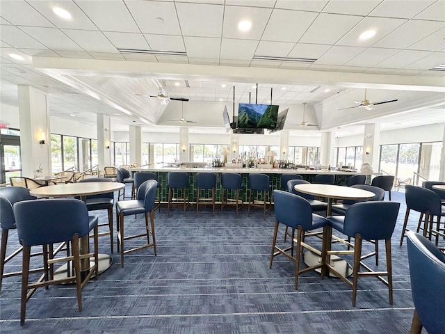 carpeted dining room with ceiling fan