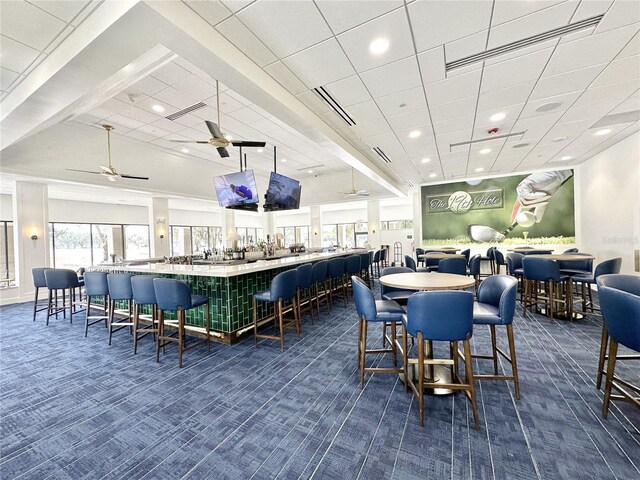 dining space featuring ceiling fan, a paneled ceiling, and dark carpet