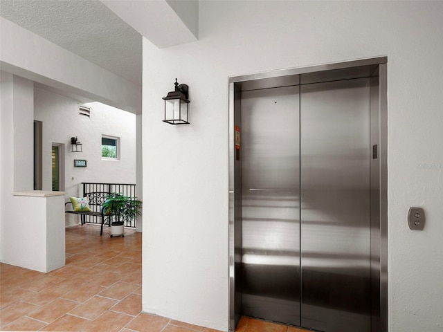 interior space with a textured ceiling and elevator