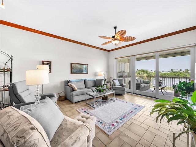 living room featuring ceiling fan, ornamental molding, and a water view