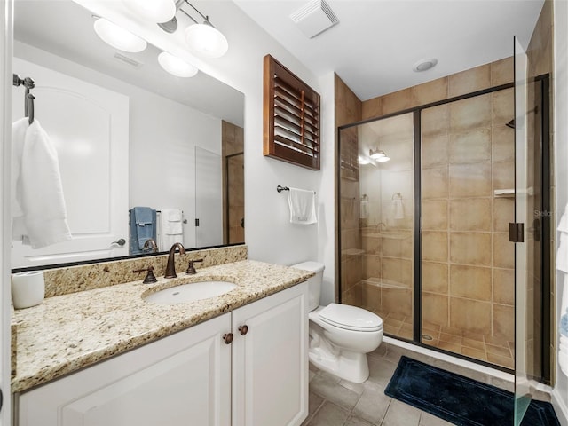 bathroom featuring walk in shower, vanity, tile patterned flooring, and toilet