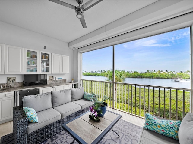 interior space with a water view and ceiling fan